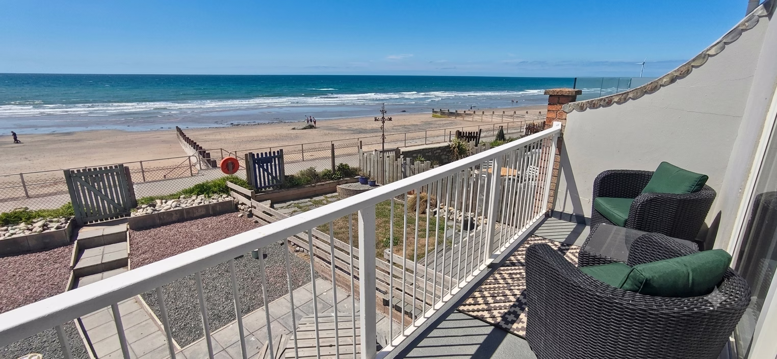 Venedotia first-floor balcony with rattan seating overlooking Tywyn beach and Cardigan Bay