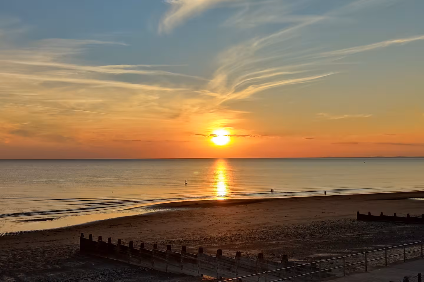 Aerial view of Tywyn seafront at golden hour, Cardigan Bay and mountains beyond, Mid-Wales